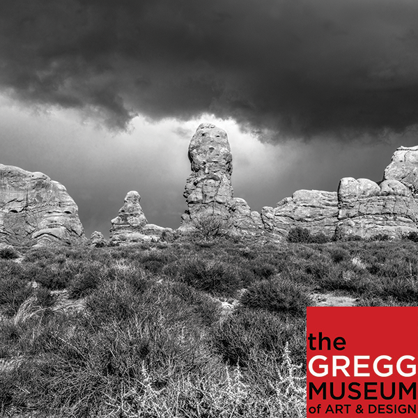 A black and white photo of a southwestern landscape by Andy Nasisse. This photo is a button to access a virtual tour.