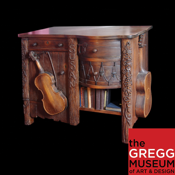 Image of an intricately carved desk. The image is a button to a virtual tour.