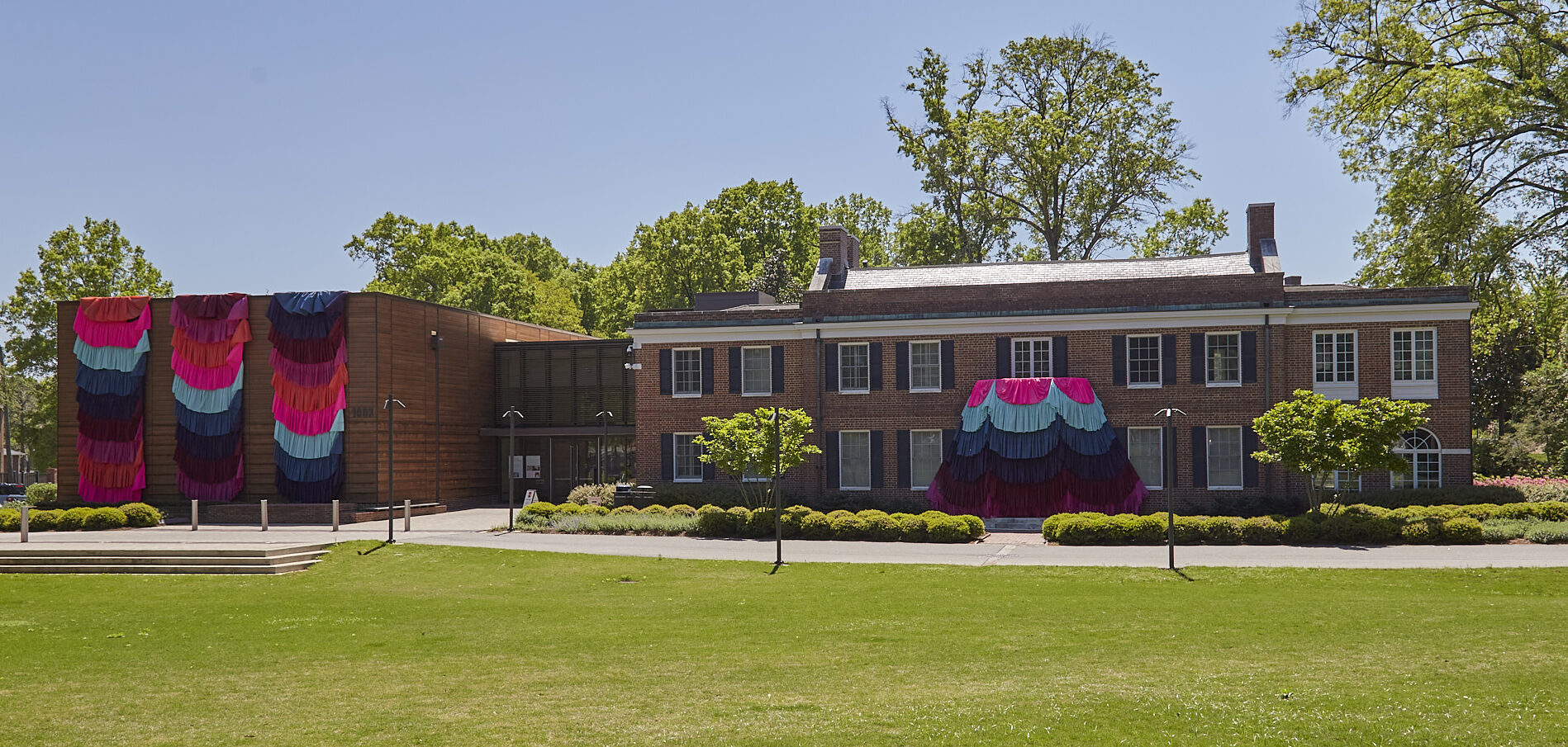The Gregg Museum front entrance adorned with multicolored fabric, which was a part of the outdoor exhibition called "Of Pleasure, Of Curiosity, Of Intelligence"